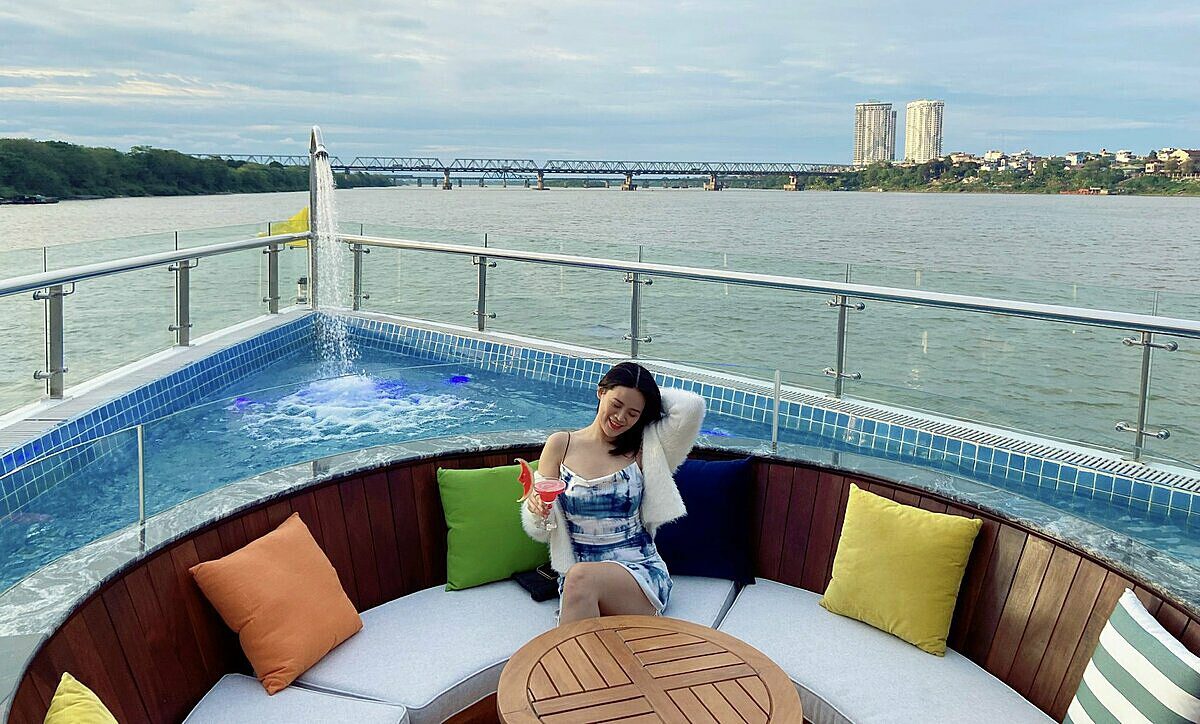 A female passenger enjoys a cup of drink on the Jade of River cruise amid the Red River in Hanoi, April 2022. Photo by VnExpress/Lan Huong